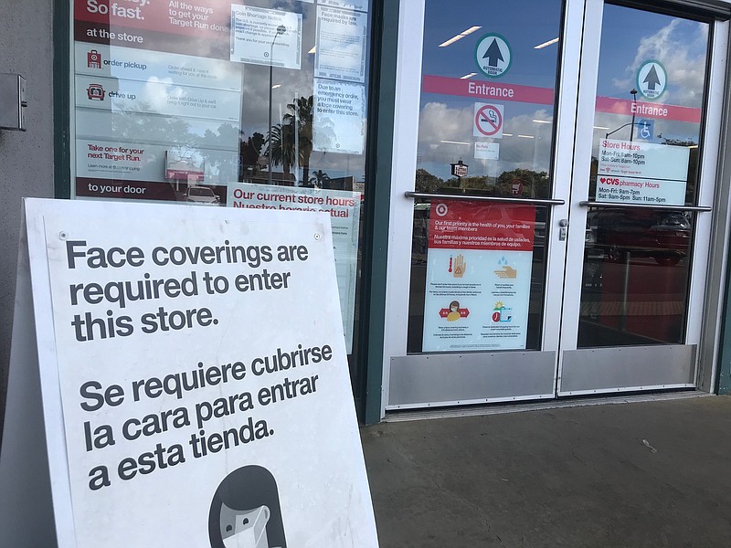 A sign advising of the store's COVID-19 prevention policies sits outside Targ...