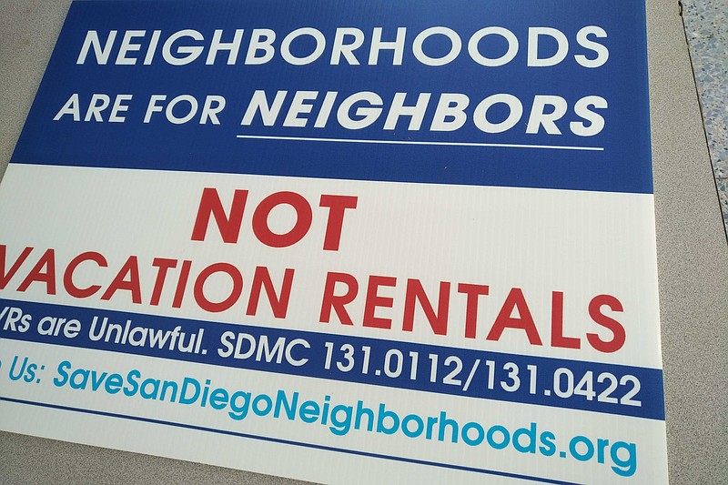 A sign lays on the ground with its message in opposition of short term vacati...